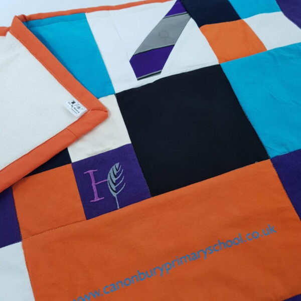 A memory blanket with orange, black, blue and white colours