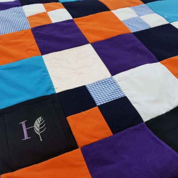 An orange, blue, white and black patchwork quilt