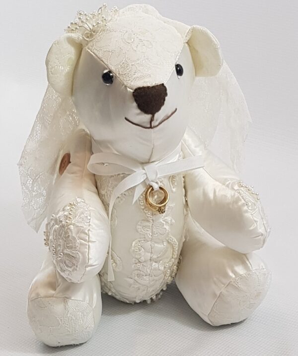 A Wedding themed memory bear with a gold ring hung from a bow around it's neck