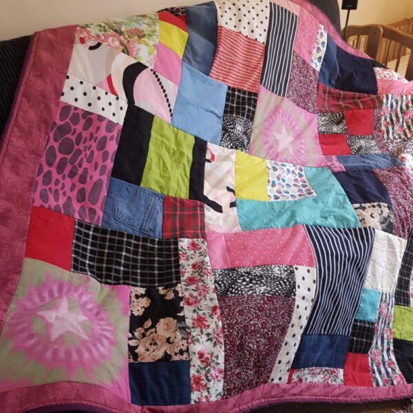 A patchwork quilt with mostly pink colours