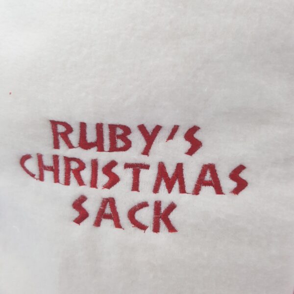 Sewn onto a product, the lettering 'Ruby's Christmas Sack'