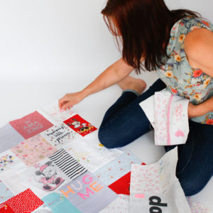 Bianca on the floor designing and putting together a large memory quilt top