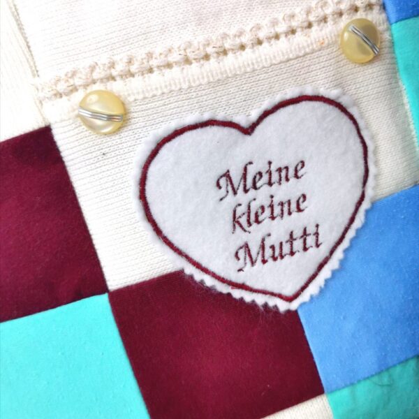 Fabric with 'Meine Kleine Mutti' sewn into the design