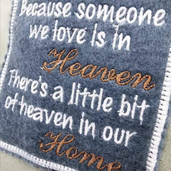 A patch with the words 'because someone we love is in heaven there's a little but of heaven in our home'