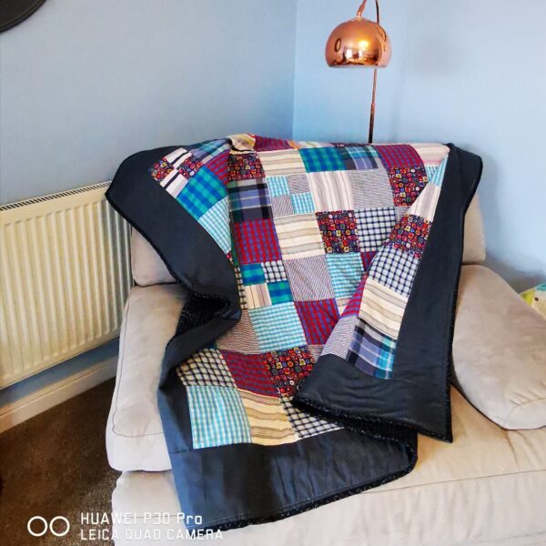 A memory blanket with a dark border on a sofa chair