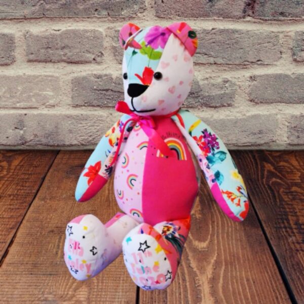 A memory bear sat against a brick wall