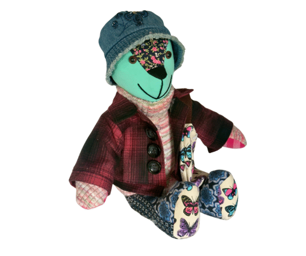 a memory bear wearing a jacket and a bucket hat
