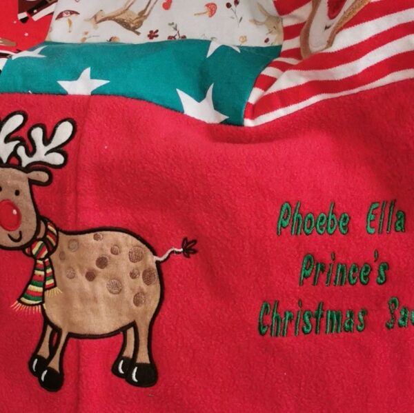 Up close view of a Christmas sack with 'Phoebe Ella Prince's Christmas Sack' sewn onto it