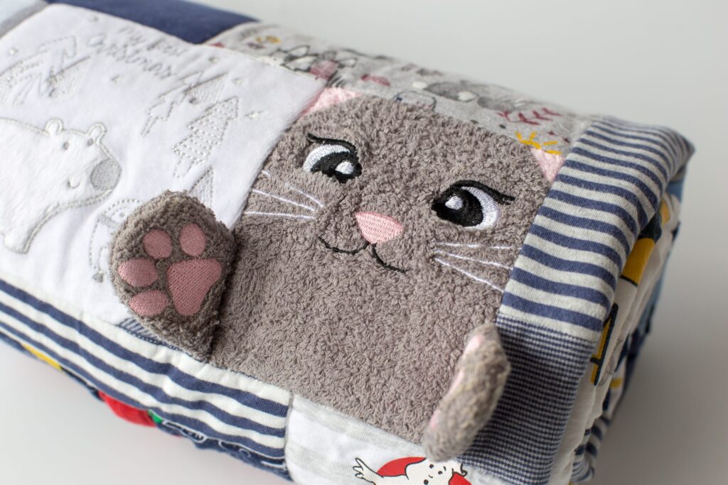 A rolled up memory blanket with a cat on it