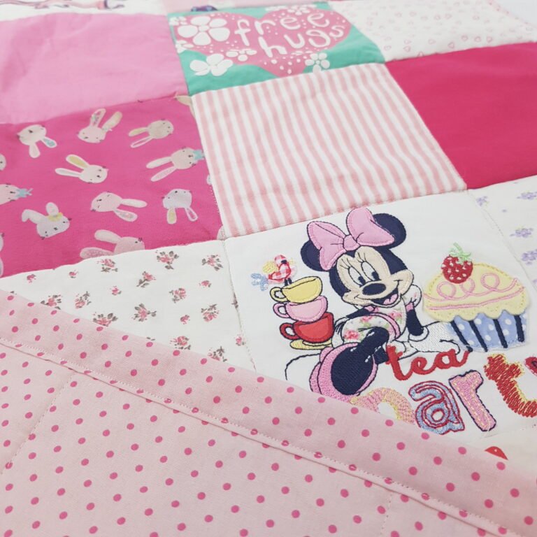 memory blanket showing pink baby clothes