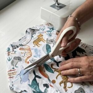 a baby outfit being cut ready to be turned into a memory quilt